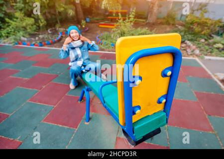 Ininfantile et childish Happy Woman ou une adolescente balance sur la seesaw.Concept de psychologie et de sociologie de la nouvelle génération et de grandir. Banque D'Images