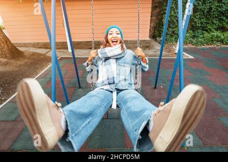 Ininfantile et childish Happy Woman ou une adolescente balance sur la seesaw.Concept de psychologie et de sociologie de la nouvelle génération et de grandir. Banque D'Images