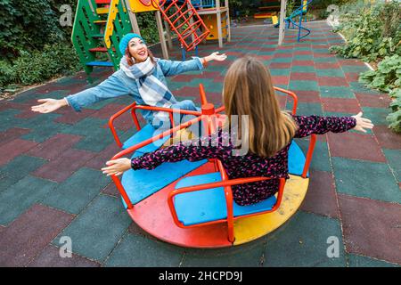 Deux amies childish Happy Woman ou adolescente s'amusent sur la mer et le carrousel sur un terrain de jeu.Concept de psychologie de la nouvelle génération et re Banque D'Images