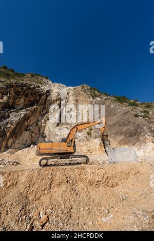Pelle tracker orange avec le marteau dans une carrière de marbre (marbre blanc Carrare) dans les Alpes Apuanes (Alpi Apuane).Toscane, Italie, Europe. Banque D'Images