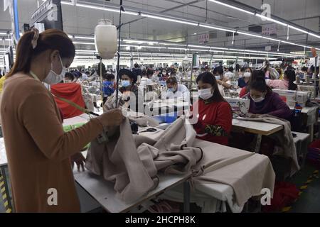 (211231) -- PHNOM PENH, le 31 décembre 2021 (Xinhua) -- les travailleurs de l'habillement font des vêtements dans une usine de Phnom Penh, au Cambodge, le 17 décembre 2021.Les responsables et les experts ont déclaré que le Cambodge avait fait naître un grand espoir sur le Partenariat économique régional global (REPC) et l'Accord de libre-échange Cambodge-Chine (ALECC) pour stimuler sa croissance économique dans l'ère post-pandémie COVID-19.Les deux accords de libre-échange doivent entrer en vigueur le 1 janvier 2022.L'Ajoug Ho, vice-président de l'Association des manufacturiers de vêtements au Cambodge, a déclaré que les deux accords apporteraient un meilleur développement pour le textile du Cambodge et g Banque D'Images