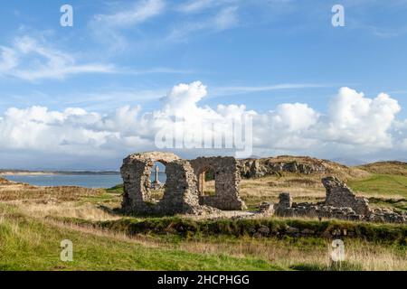 La croix celtique et les ruines de l'église St Dwynwen sur l'île de Llanddwyn, île d'Anglesey, au nord du pays de Galles Banque D'Images