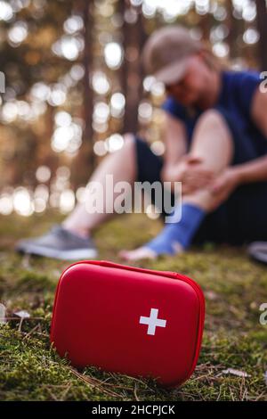 Trousse de premiers soins et femme touriste blessée et défocusée à la cheville de la forêt.Accident et blessure lors de randonnées dans la nature Banque D'Images