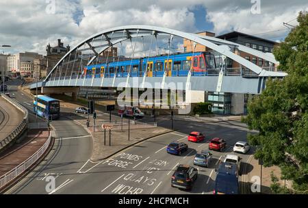 Sheffield classe 399 tramway en direction de la cathédrale traversant le pont suspendu de Park Square l'après-midi ensoleillé, avec circulation routière et routière en dessous Banque D'Images