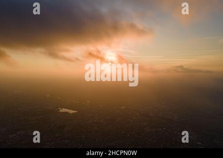 Vue aérienne depuis la haute altitude de la ville éloignée couverte de cumulus bouffieux qui se forment avant la pluie en soirée.Point de vue de l'avion du ciel nuageux Banque D'Images