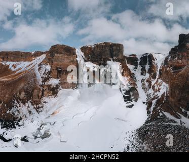 Vue aérienne par drone de la cascade de Haifoss en Islande pendant l'hiver dans les Highlands.Ciel bleu et nuages dans la neige. Banque D'Images