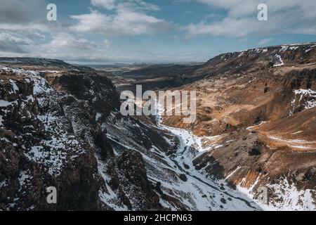 Vue aérienne par drone de la cascade de Haifoss en Islande pendant l'hiver dans les Highlands.Ciel bleu et nuages dans la neige. Banque D'Images