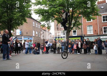 Homme en train de jouer sur un monocycle dans la rue devant les spectateurs à York, en Angleterre Banque D'Images