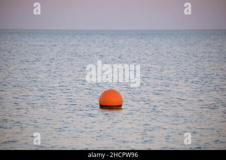 Bouée orange flottant sur les vagues de la surface de la mer.Concept de sécurité de la vie humaine. Banque D'Images