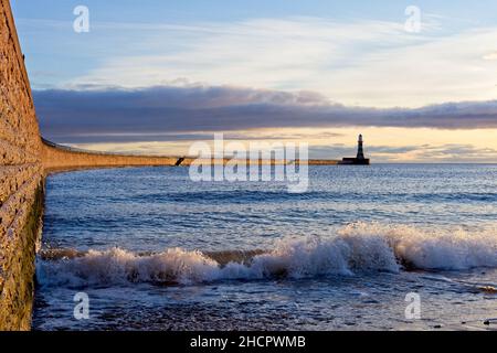 Vagues entrant contre le mur de Roker Pier en direction de Roker Lighthouse sur la côte de la mer du Nord à Sunderland, Tyne et Wear. Banque D'Images