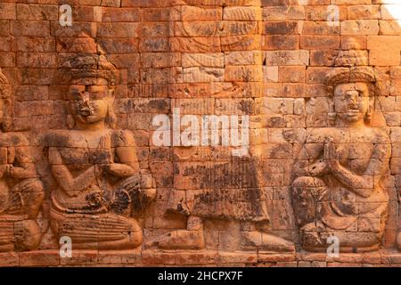 Relief sur un mur, représentation de deux personnages à genoux priant, à Prasat Kravan, un temple hindou du 10th siècle, dans le P archéologique d'Angkor Banque D'Images