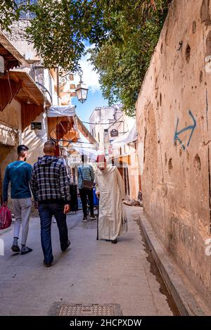 Homme senior dans la djellaba marocaine traditionnelle et chapeau marchant dans la rue Banque D'Images