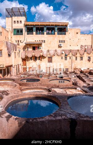 L'eau de teinte remplit les réservoirs dans la tannerie contre l'ancien bâtiment résidentiel Banque D'Images