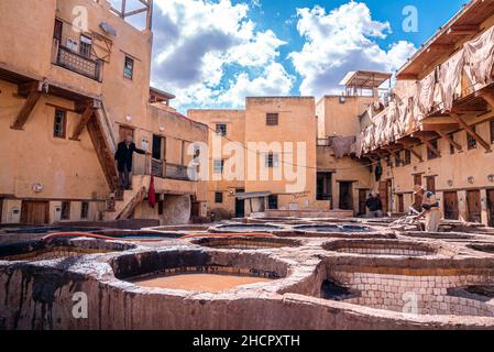 L'eau de teinte remplit les réservoirs dans la tannerie contre l'ancien bâtiment résidentiel Banque D'Images