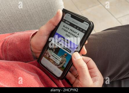 Gros plan de la personne de l'homme regardant Black Friday et Cyber Monday site Web sur iphone smartphone téléphone Angleterre Royaume-Uni GB Grande-Bretagne Banque D'Images