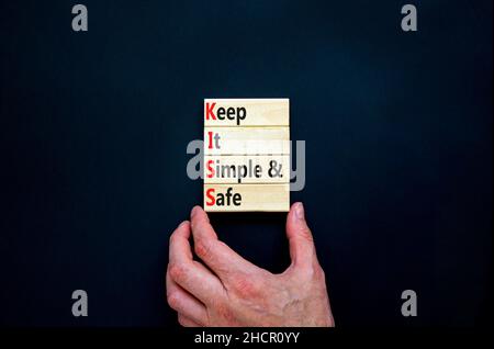 SYMBOLE KISS Keep IT simple and safe.Les mots de concept KISS permettent de garder des blocs de bois simples et sûrs.Belle table noire, fond noir.Business et K Banque D'Images