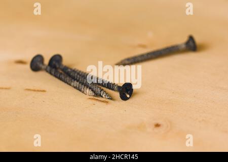 Vis noire sur une planche en bois.Gros plan. Banque D'Images