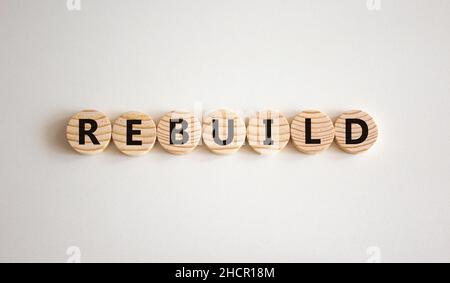 Reconstruire et construire le symbole.Le mot concept reconstruire sur des cercles en bois.Magnifique arrière-plan blanc, espace de copie.Concept de reconstruction et de construction d'entreprise. Banque D'Images