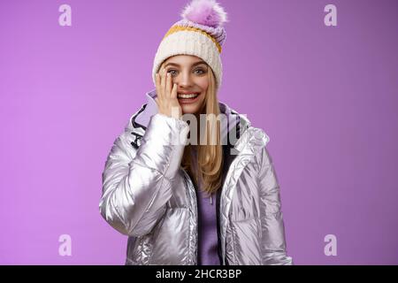 Enchantée, imbécile blonde tendre et imbécile, elle joue avec plaisir boules de neige toucher joue étonnement sentir rêve devenu réalité profiter de vacances Banque D'Images