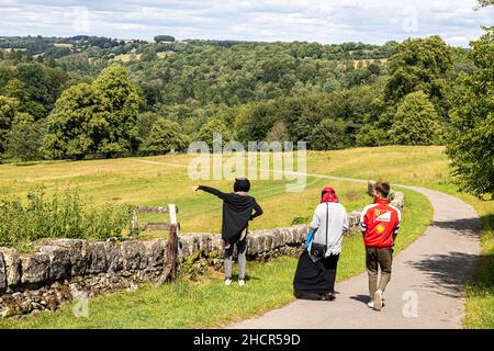 Marcheurs en marchant sur un sentier public sur le domaine de Miserden Park dans le village de Cotswold de Miserden, Gloucestershire Royaume-Uni Banque D'Images