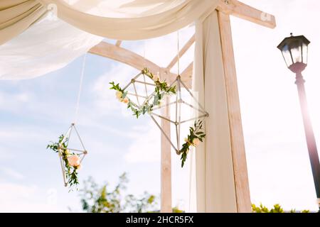 Losange décoratif avec petites roses de thé sur une arche de mariage.Vue de dessous Banque D'Images