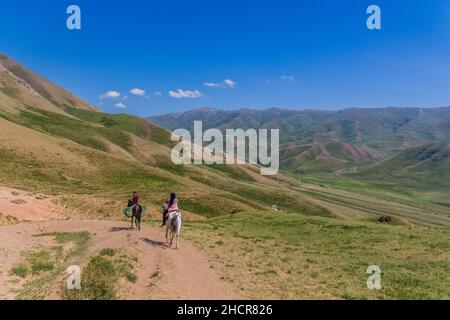 Cavaliers dans les montagnes près du lac Song Kul, Kirghizistan Banque D'Images