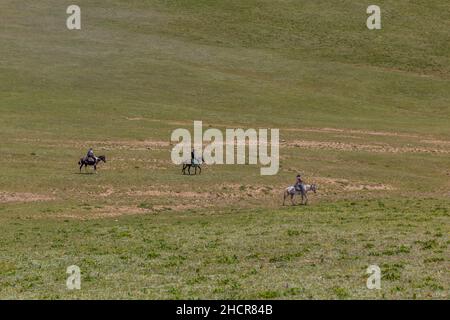 SONG KUL, KIRGHIZISTAN - 23 JUILLET 2018 : les touristes voyagent à cheval près du lac Song Kul, Kirghizistan Banque D'Images