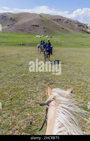 SONG KUL, KIRGHIZISTAN - 23 JUILLET 2018 : touristes à cheval près du lac Song Kul, Kirghizistan Banque D'Images