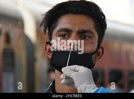 Mumbai, Inde.31st décembre 2021.Un professionnel de la santé recueille un échantillon d'écouvillonnage nasal auprès d'un homme à la gare de Dadar à Mumbai.en raison de l'augmentation des cas d'Omicron dans la ville,Les passagers arrivant de la station de sortie qui ne sont pas entièrement vaccinés ou qui ne sont pas accompagnés d'un rapport de RT PCR négatif doivent subir des tests par écouvillonnage nasal à la gare ferroviaire avant d'être autorisés à se rendre à leur destination respective.Crédit : SOPA Images Limited/Alamy Live News Banque D'Images