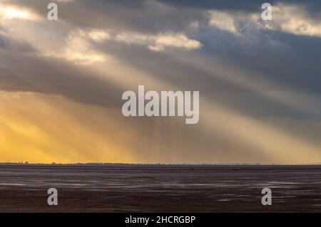 Rayons crépusculaires ou solaires brisant à travers les nuages au-dessus de la mer à RSPB snettisham et le lavage sur la côte nord de norfolk en automne, rayons lumineux, Banque D'Images