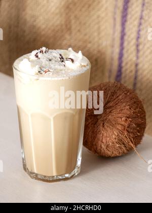 Latte à la noix de coco dans un grand verre et noix de coco sur une balançoire dans un café.Gros plan. Banque D'Images