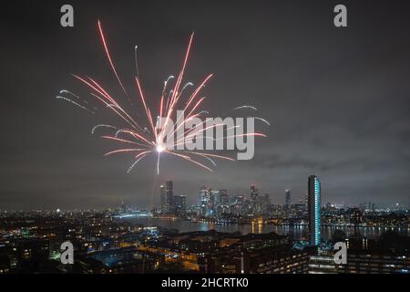Londres, Royaume-Uni.1st janvier 2022.Feux d'artifice du nouvel an : des feux d'artifice locaux sont lancés dans le sud-est de Londres avec vue sur les bâtiments du parc d'affaires de Canary Wharf.Credit: Guy Corbishley/Alamy Live News Banque D'Images