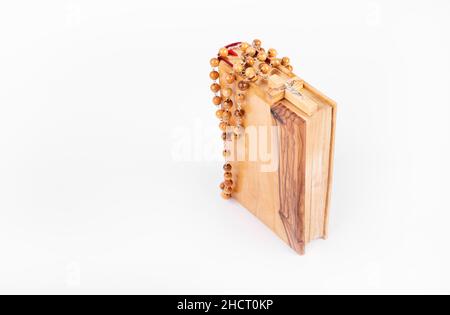 Bible avec croix en bois isolée sur fond blanc Banque D'Images