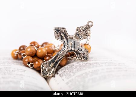 Bible avec rosaire en bois isolé sur fond blanc Banque D'Images