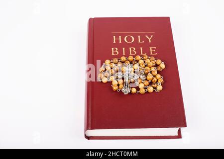 Bible avec rosaire en bois isolé sur fond blanc Banque D'Images