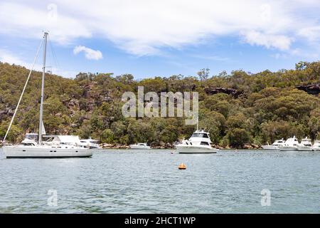 Refuge Bay, Cowan Creek sur la rivière Hawkesbury avec des bateaux à moteur et des yachts à voile amarrés sur des bouées à refuge Bay pendant l'été, Sydney, Australie Banque D'Images