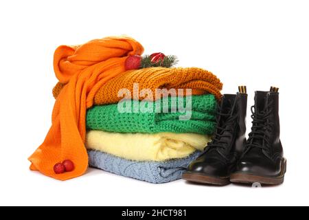Pile de chandails, écharpe, chaussures et décoration de Noël sur fond blanc Banque D'Images