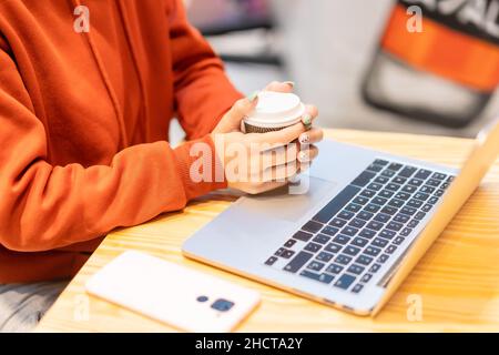 Personne méconnaissable ayant un café lisant un e-mail sur l'ordinateur Banque D'Images