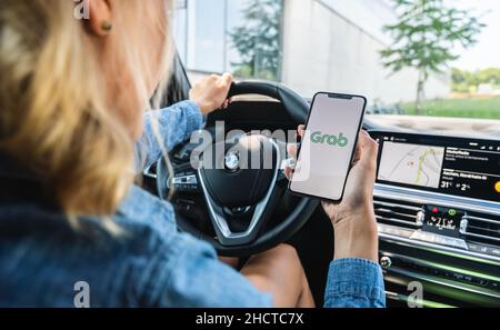 Femme main tenant iphone X avec logo de l'application de Grab dans une voiture.Grab est une application pour smartphone tout-en-un pour la réservation de transport en Asie du Sud-est. Banque D'Images