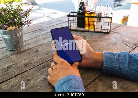 Femme tenant main iphone X avec le logo de la Balance dans un restaurant à payer.Lira Facebook crypto-monnaie et bitcoin crypto-monnaie smartphone Share, Lib Banque D'Images