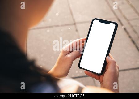 Image de maquette d'un téléphone portable avec écran blanc vierge en ville en été Banque D'Images