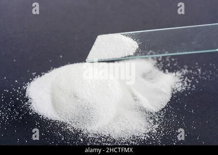 Prise de vue à grand angle de poudre blanche sur une surface noire et sur un testeur de verre Banque D'Images