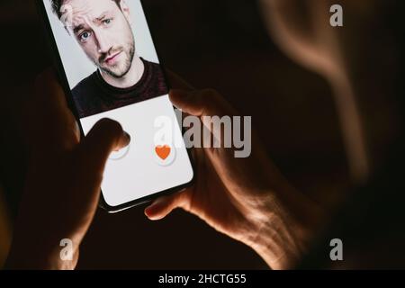 Femme donnant un comme à la photo sur les médias sociaux ou de glisser sur l'application de rencontres en ligne.Appuyez avec le doigt sur l'icône en forme de cœur à l'écran dans l'application pour smartphone.Ami, f Banque D'Images