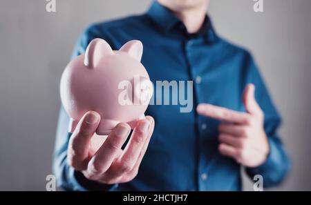 Young man holding a piggy bank Banque D'Images