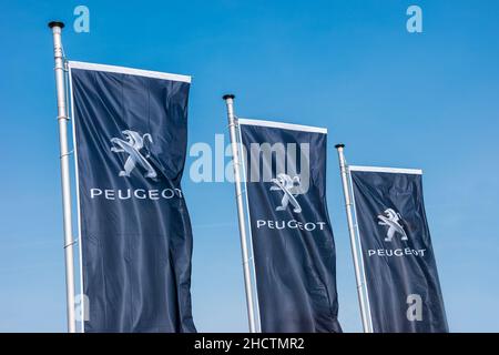 Drapeau Peugeot contre ciel bleu au magasin Peugeot.Peugeot est une marque automobile française, qui fait partie de PSA Peugeot Citroën. Banque D'Images