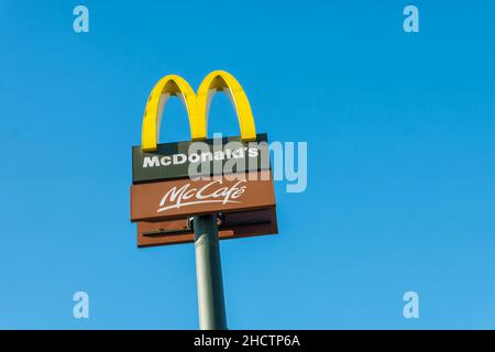 Affiche du restaurant McDonald's contre le ciel bleu.McDonald's Corporation est la plus grande chaîne de restaurants de restauration rapide au monde. Banque D'Images