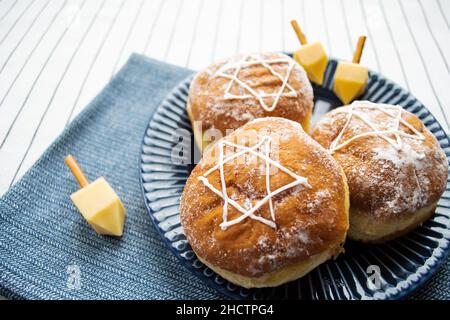 Bonne Hanoukkah.Un régal traditionnel de beignets avec David star et dreidel fait à partir de fromage et de bâtonnets de biscuit.Copier l'espace. Banque D'Images