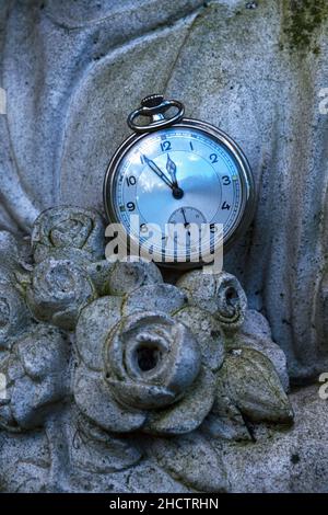 gros plan d'une vieille montre de poche sur une sculpture en pierre Banque D'Images