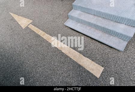Flèche vers l'avant sur la route et les escaliers Banque D'Images