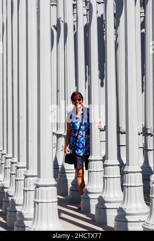 Une touriste féminine regarde de l'installation d'art Urban Light.Los Angeles County Museum of Art California, États-Unis d'Amérique Banque D'Images